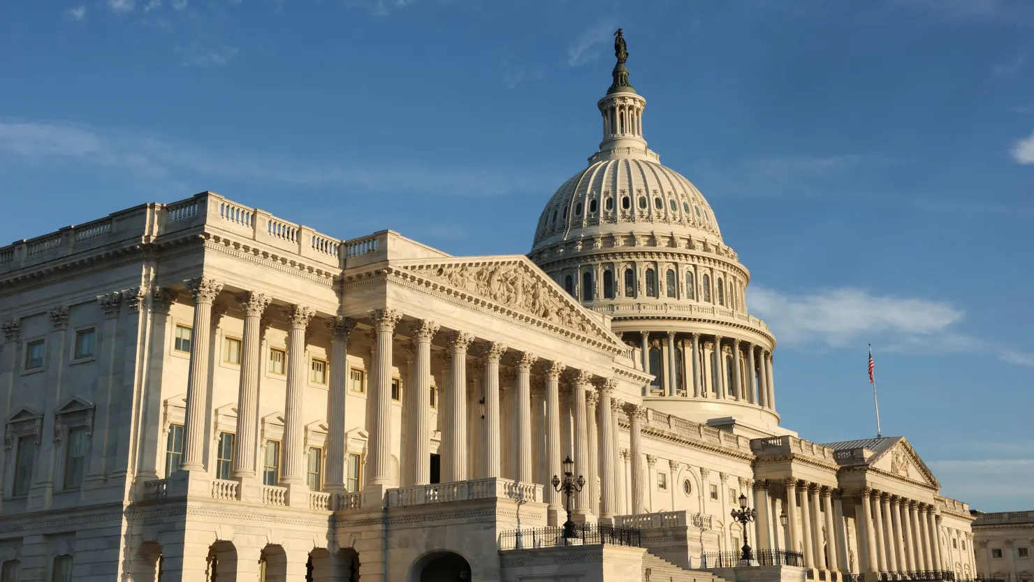 Capitol in Washington at night with US flag