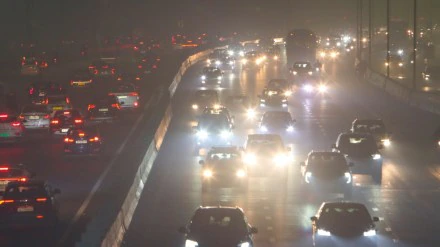Dense smog over Delhi roads with vehicles moving slowly