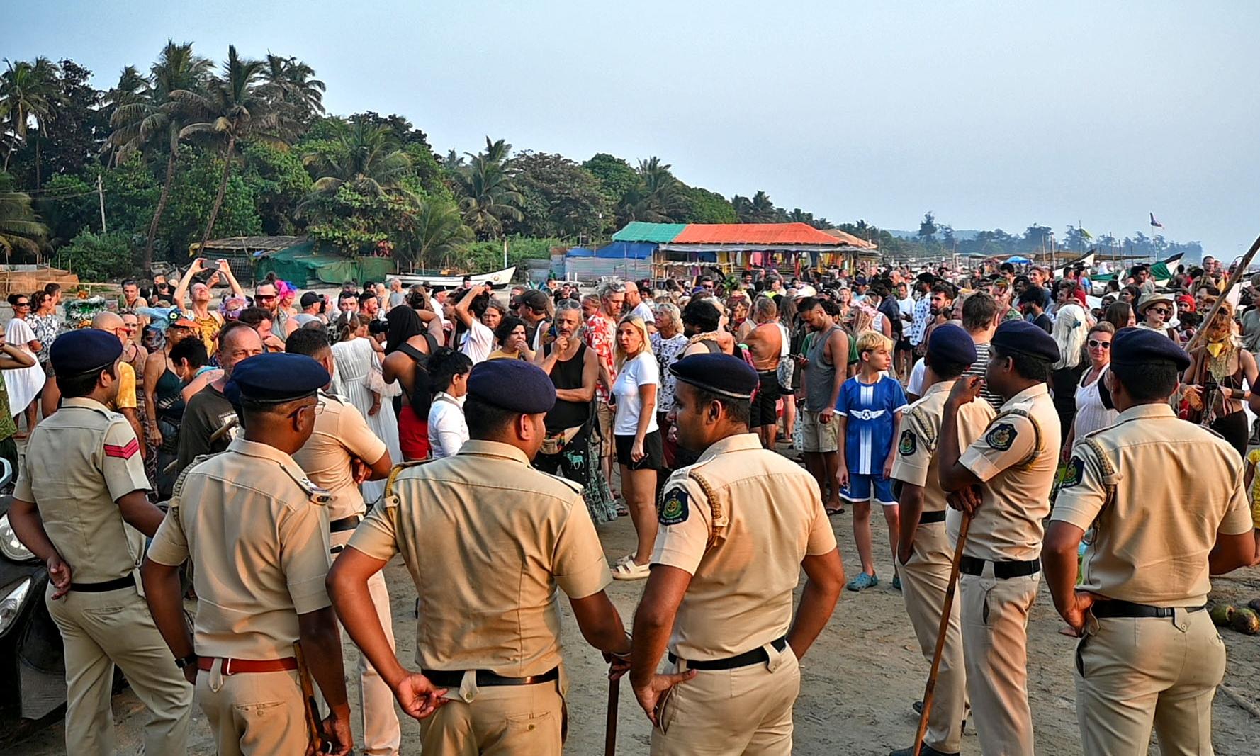 Crowded Goa beach with tourists, police patrolling for safety