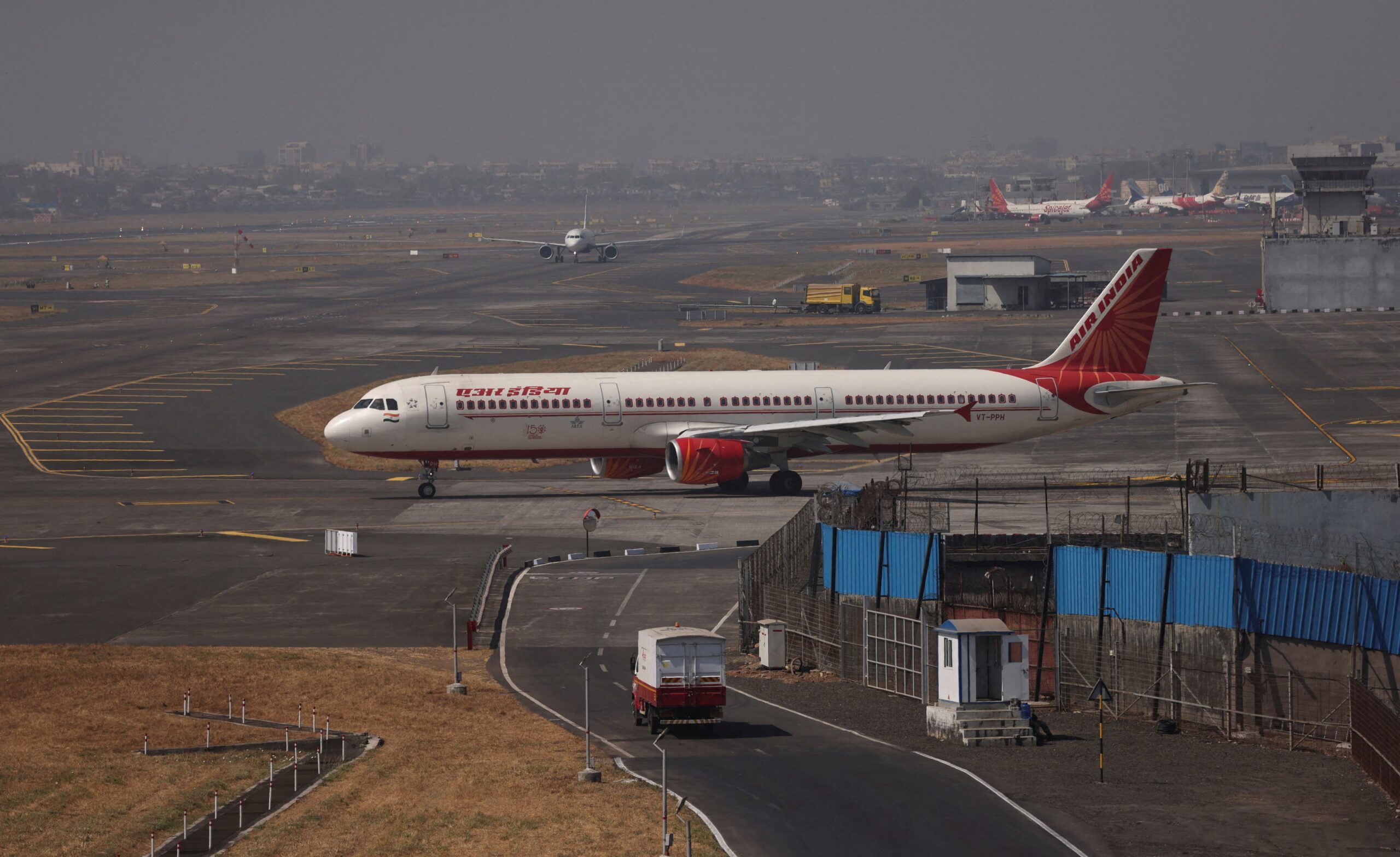Air India aircraft parked on the tarmac as fuel trucks operate nearby at night